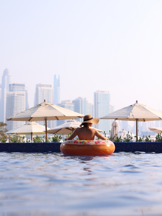 Lady in the pool in a floaty enjoying the sunset views on the pool