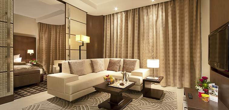 big living room with satellite TV, air conditioning and comfortable modern furniture including couches and tables and large windows with panoramic views of Abu Dhabi city in the United Arab Emirates