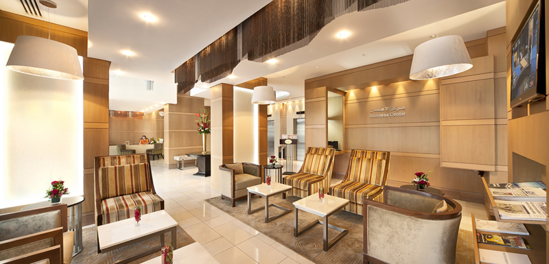 friendly, English speaking hotel reception staff welcome guests in lobby of Oaks Liwa Executive Suites in Abu Dhabi, United Arab Emirates